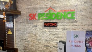 A reception desk with a stone wall background, a sign for SK Residence Patong, and a Wi-Fi sign. - SK Residence And Restaurant Patong  (Patong)