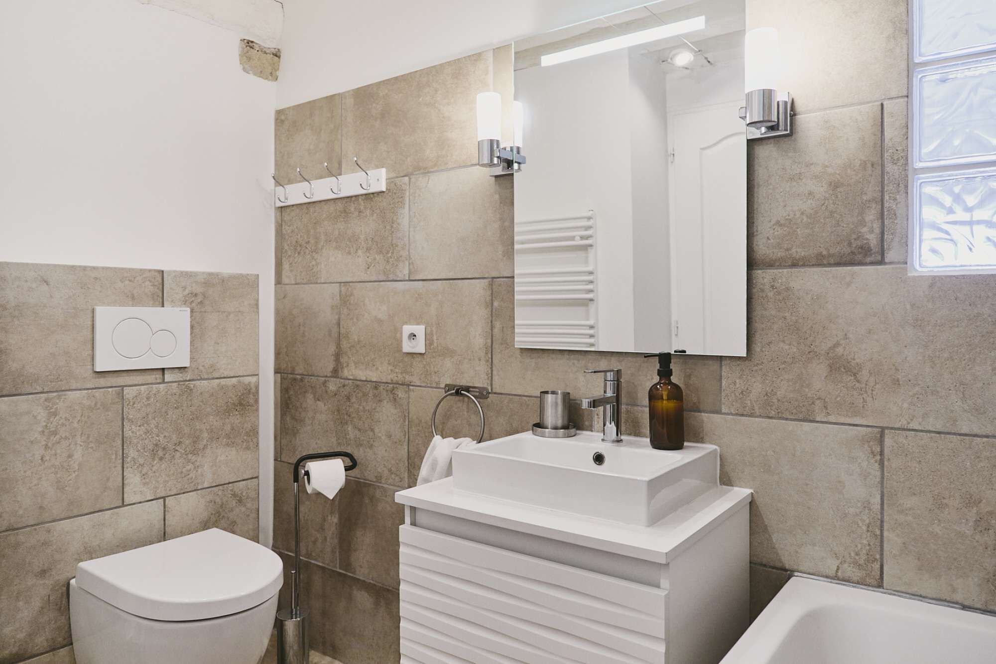 Un baño moderno con inodoro, lavamanos y bañera.