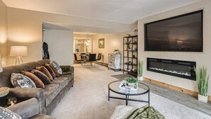 A living room with a sofa, coffee table, TV, fireplace, and dining area. - Minutes from Keystone Resort, come enjoy mountain living! (Keystone)