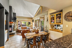 A spacious living area with a fireplace, a dining table, and comfortable seating. - 4BR Snow Day Getaway | Fireplace & Shuttle (Steamboat Springs)
