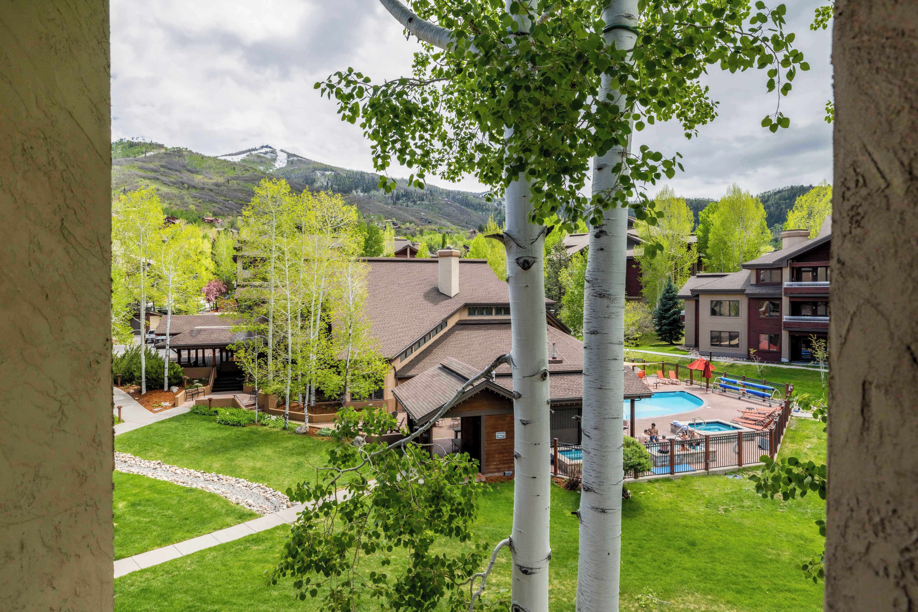 Un complexe hôtelier doté d’une piscine, d’un patio couvert et offrant une vue sur les montagnes.