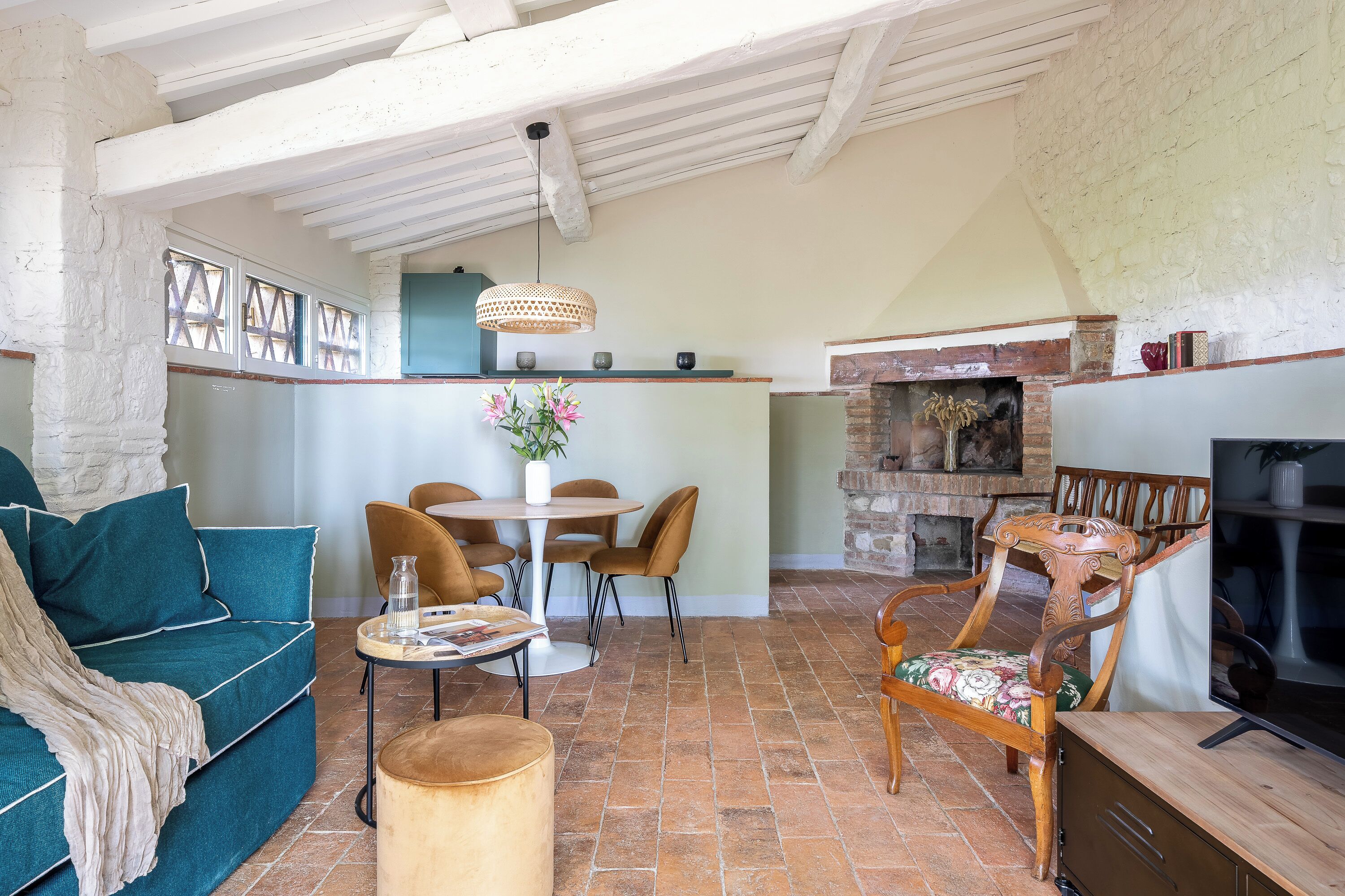 A cozy living room with a sofa, chairs, a coffee table, and a fireplace.