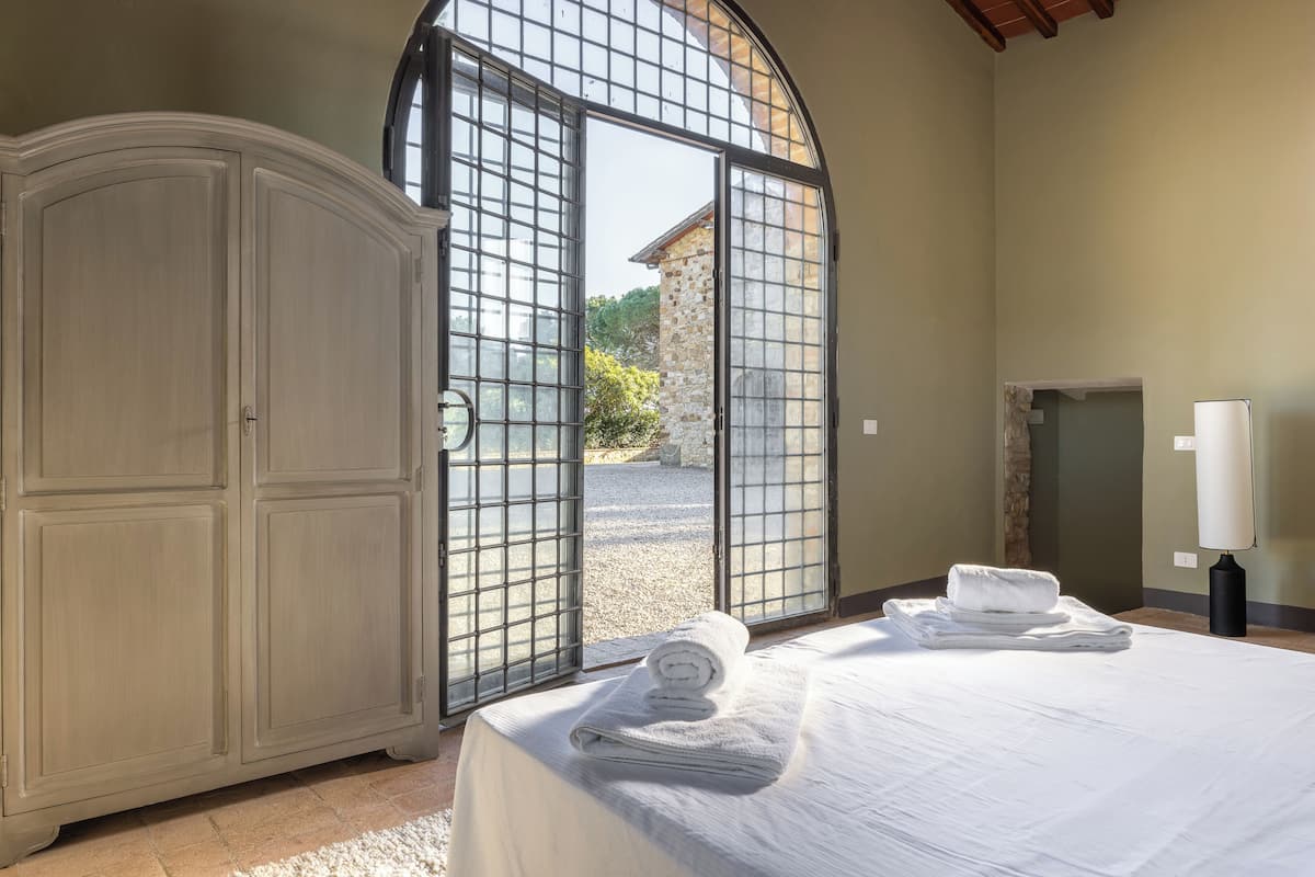 Un dormitorio con cama, armario y puerta que da al exterior.