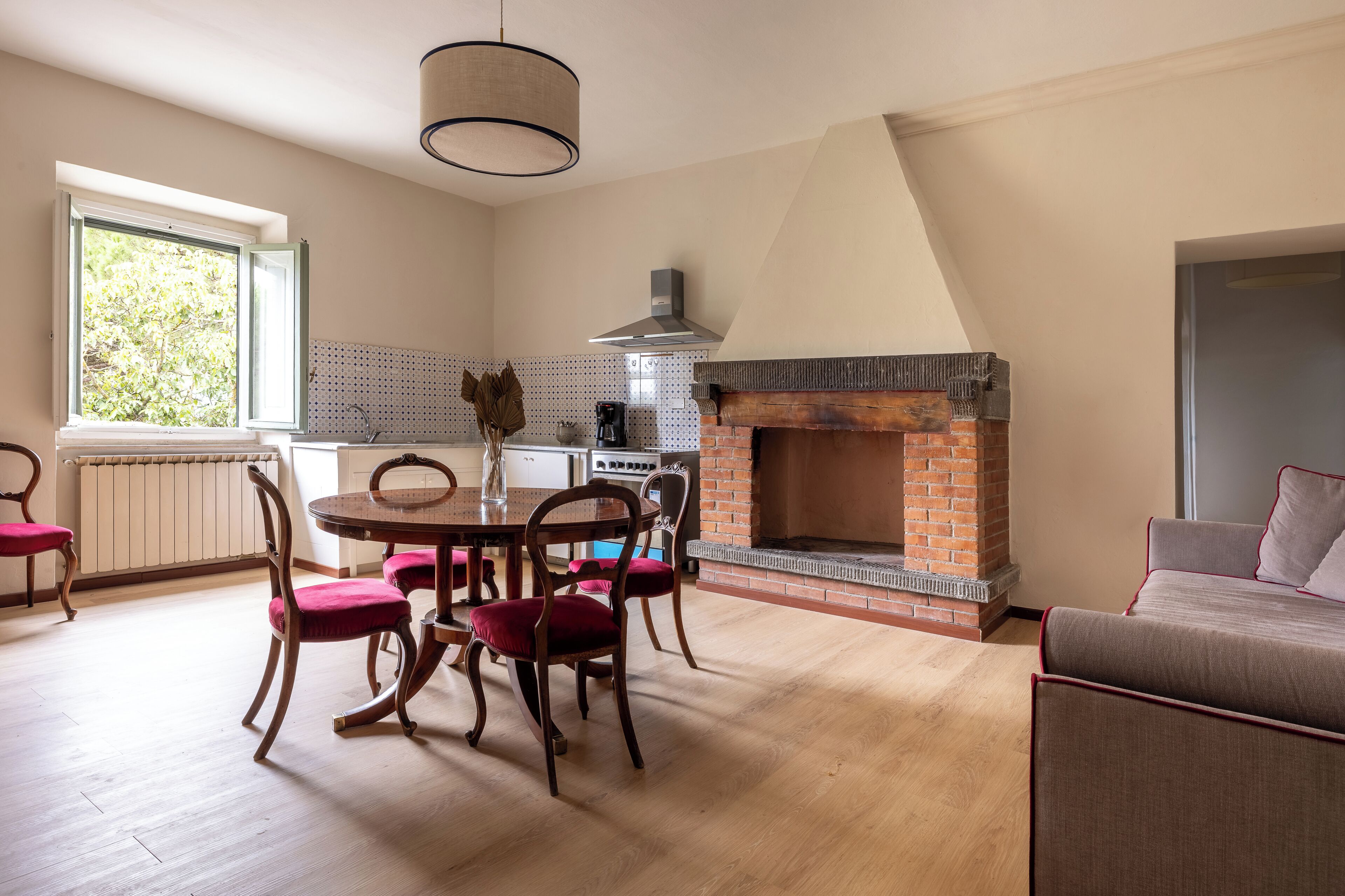 Una cocina moderna con chimenea de ladrillo, mesa de madera y sillas.