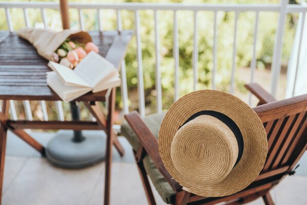 A wooden chair with a straw hat on it, a book, and a bouquet of flowers on a wooden table. - Idonia Sea View Double Room  (Hvar)