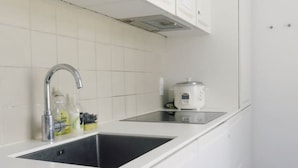 A kitchen with white cabinets, a double sink, and a microwave. - Close to Norreport st and walking street. 305 (København)