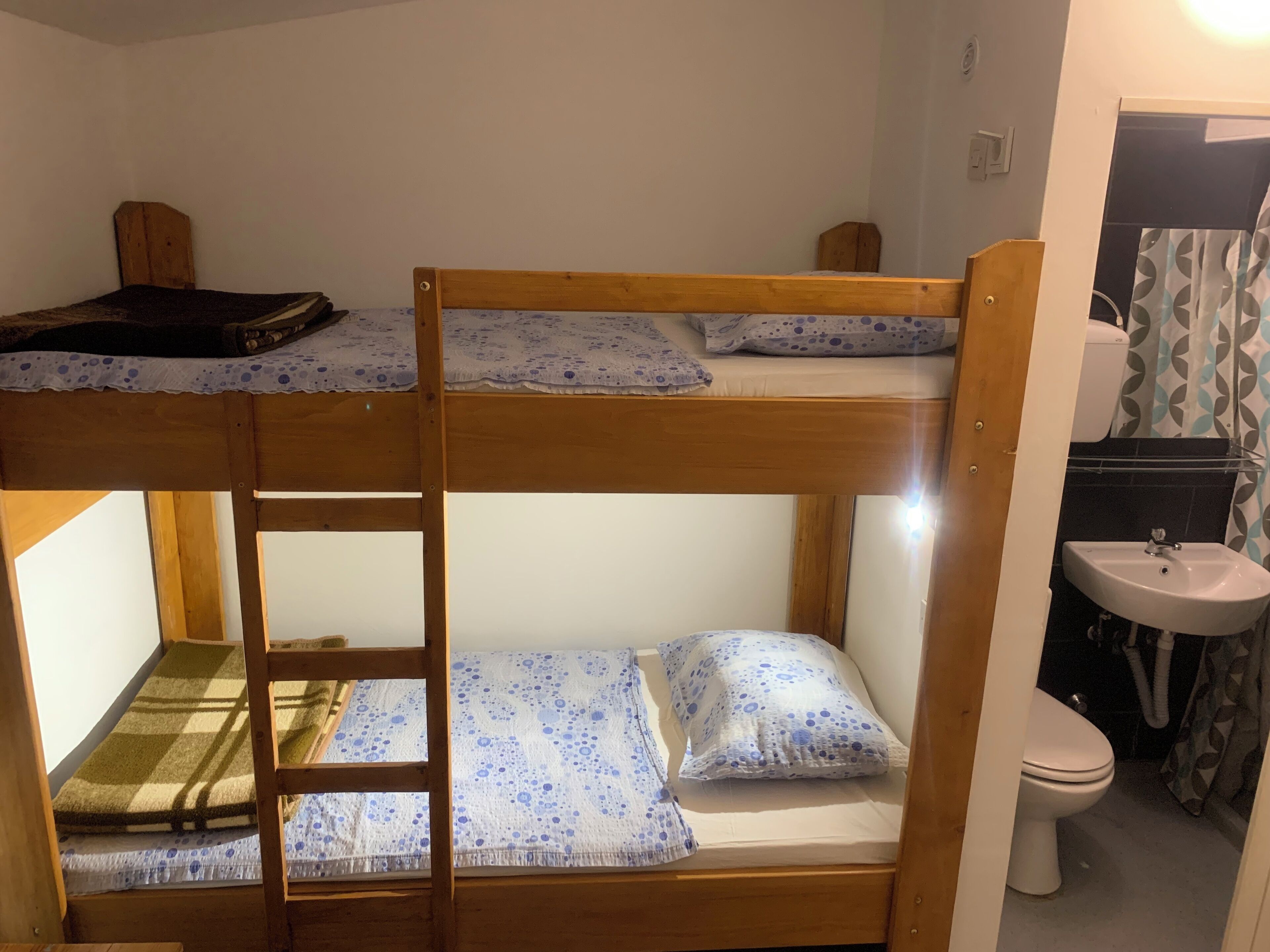 Dormitorio con literas, un lavamanos y un inodoro.