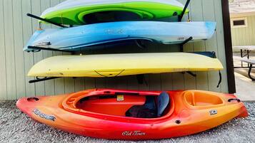 Kayaks of various colors and designs, including a red kayak labeled "Old Town" and others in green, blue, and yellow.