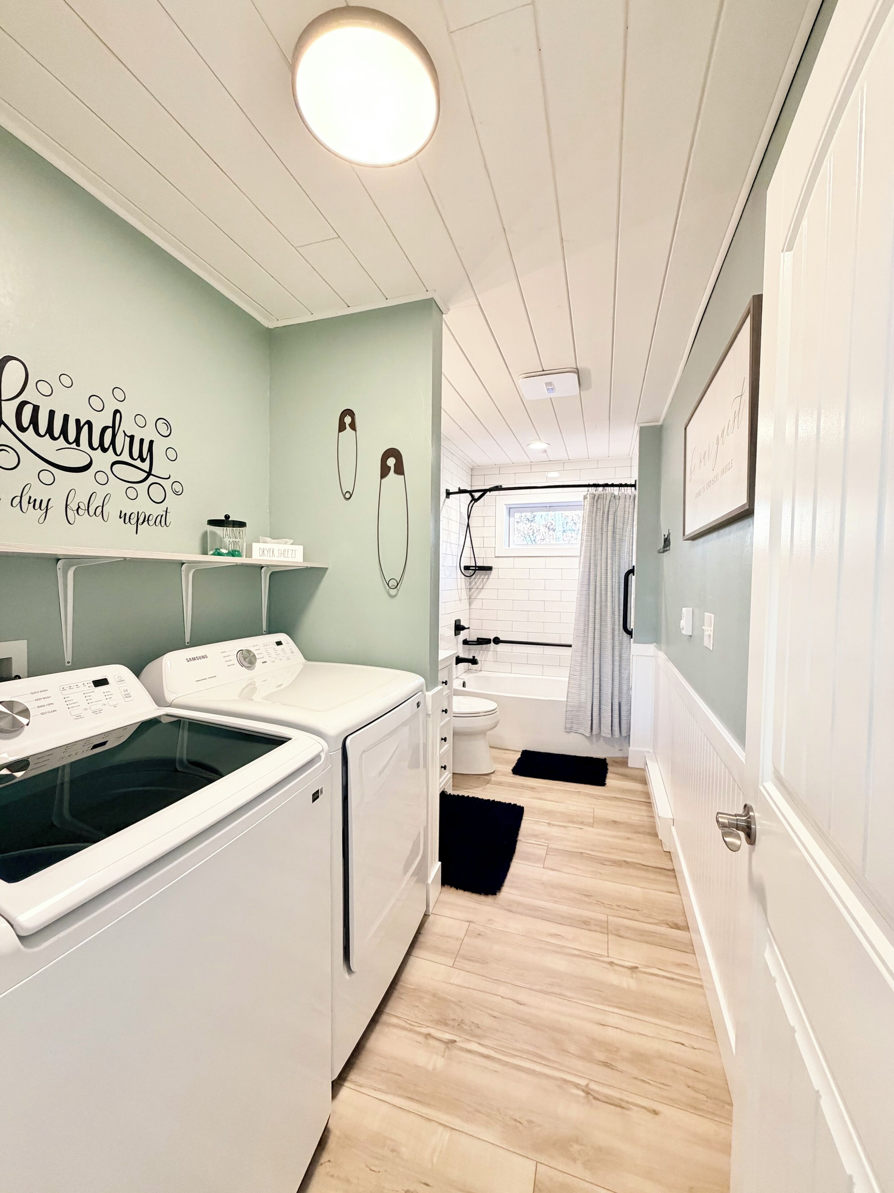 A laundry room with a Samsung washer and dryer, a toilet, and a shower area.