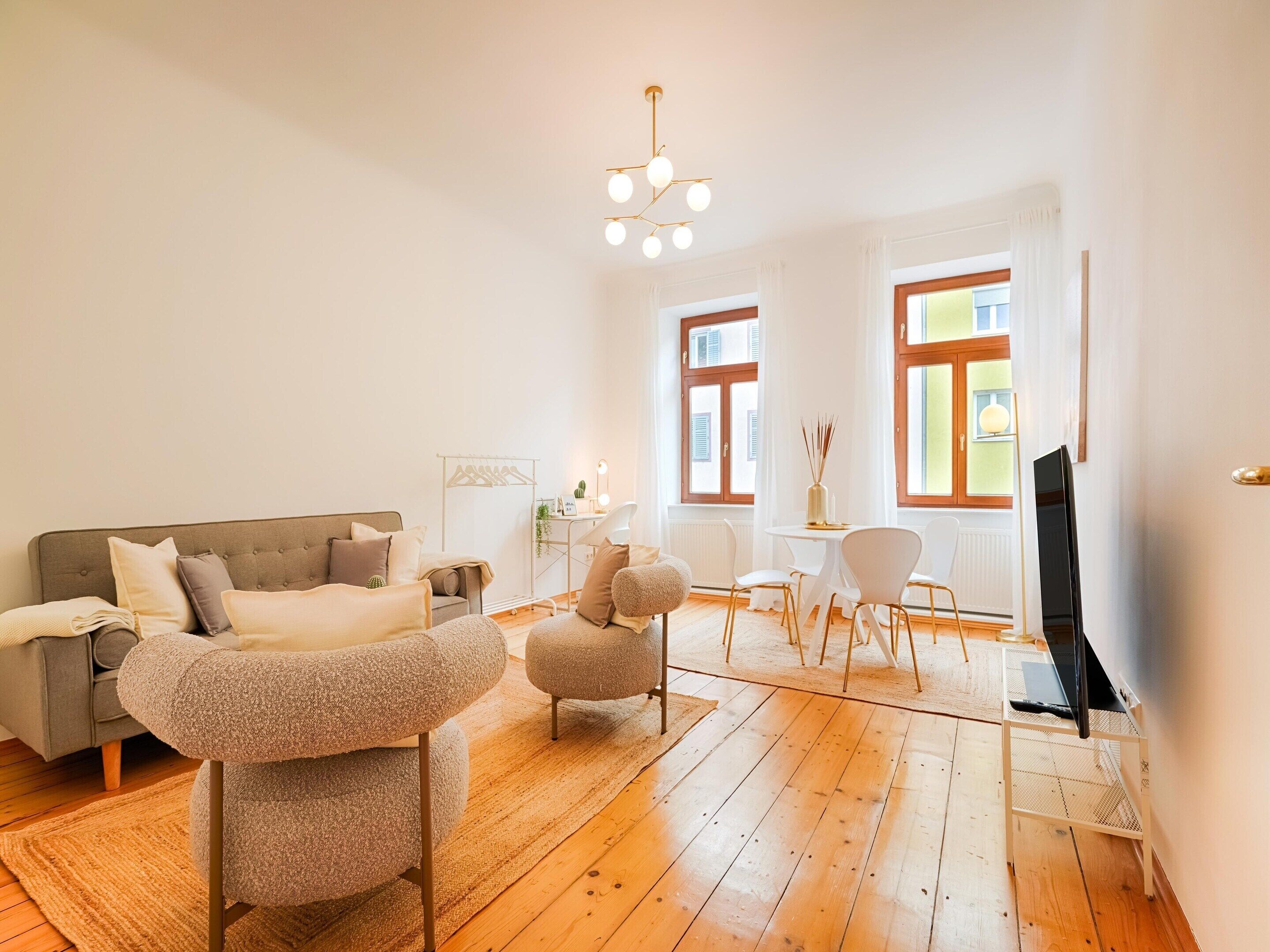 Un salon moderne avec un canapé, un pouf et un meuble pour la télévision.