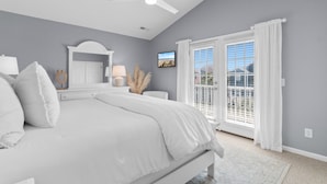 A bedroom with a bed, a ceiling fan, a TV, and a window with curtains. - Retreat w/ Private Pool & Ocean View in Surfside Beach (Surfside Beach)