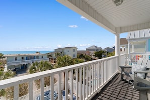 Ein Balkon mit Blick auf den Strand und weitere GebÀude.