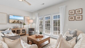 A living room with a wooden coffee table, a television, a sofa, and a cabinet. - Retreat w/ Private Pool & Ocean View in Surfside Beach (Surfside Beach)