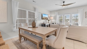 A spacious living area with a dining table, a sofa, and a ceiling fan. - Retreat w/ Private Pool & Ocean View in Surfside Beach (Surfside Beach)