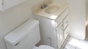 Ein Badezimmer mit Toilette, Waschbecken und Spiegel.