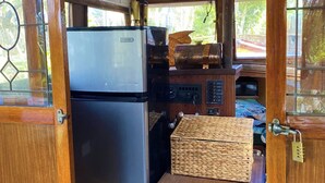 Una cocina pequeña con un refrigerador, estufa y encimera de madera.