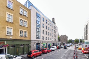A street view with a building labeled "MACBOURNE" and a red car parked in front. - For Students Only Studio Living at Lady Nicolson Court (Edinburgh)