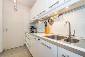 A modern kitchen with two stainless steel sinks, a coffee maker, and a knife block.
