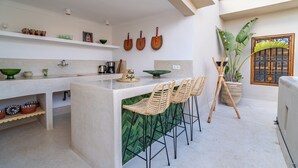 A modern kitchen with a central island, bar stools, and decorative items on shelves. - Authentic 5-bedroom Riad with swimming pool in the heart of Marrakech's Medina (Marrakech)
