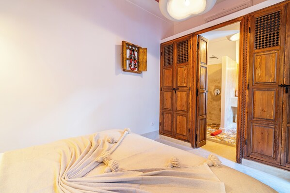Une pièce comprenant un lit, une armoire en bois et une petite décoration fixée au mur.