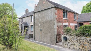 A two-story house with a stone facade and a brick extension. - Corner Cottage (Ashbourne)