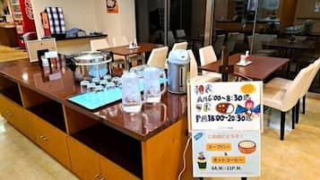 A restaurant counter with a menu board, water pitchers, and a coffee machine.
