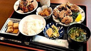 A tray with various Japanese dishes including rice, tempura, and a bowl of soup.
