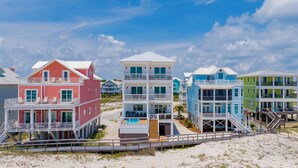 A beachfront property with multiple-story houses, each featuring balconies and a pool. - Gulf Front Luxury | Private Heated, Cooled Pool | Elevator and EV Charging (Gulf Shores)