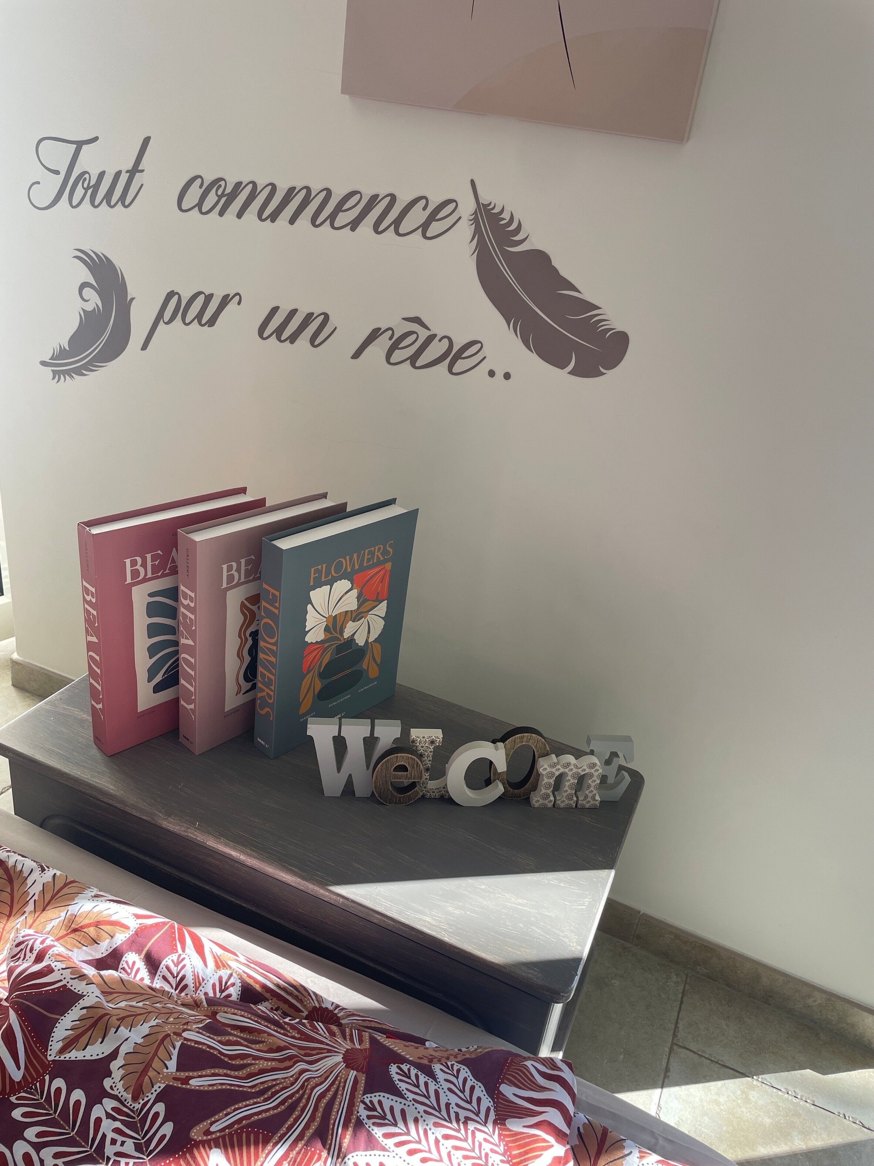 A bookshelf with books and a welcome sign.