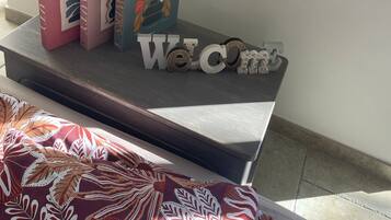 A bookshelf with books and a welcome sign.