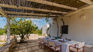 An outdoor dining area with a covered pergola, white tablecloths, and wooden chairs. - Ker Rail Villa With Pool by Wonderful Italy (Ostuni)