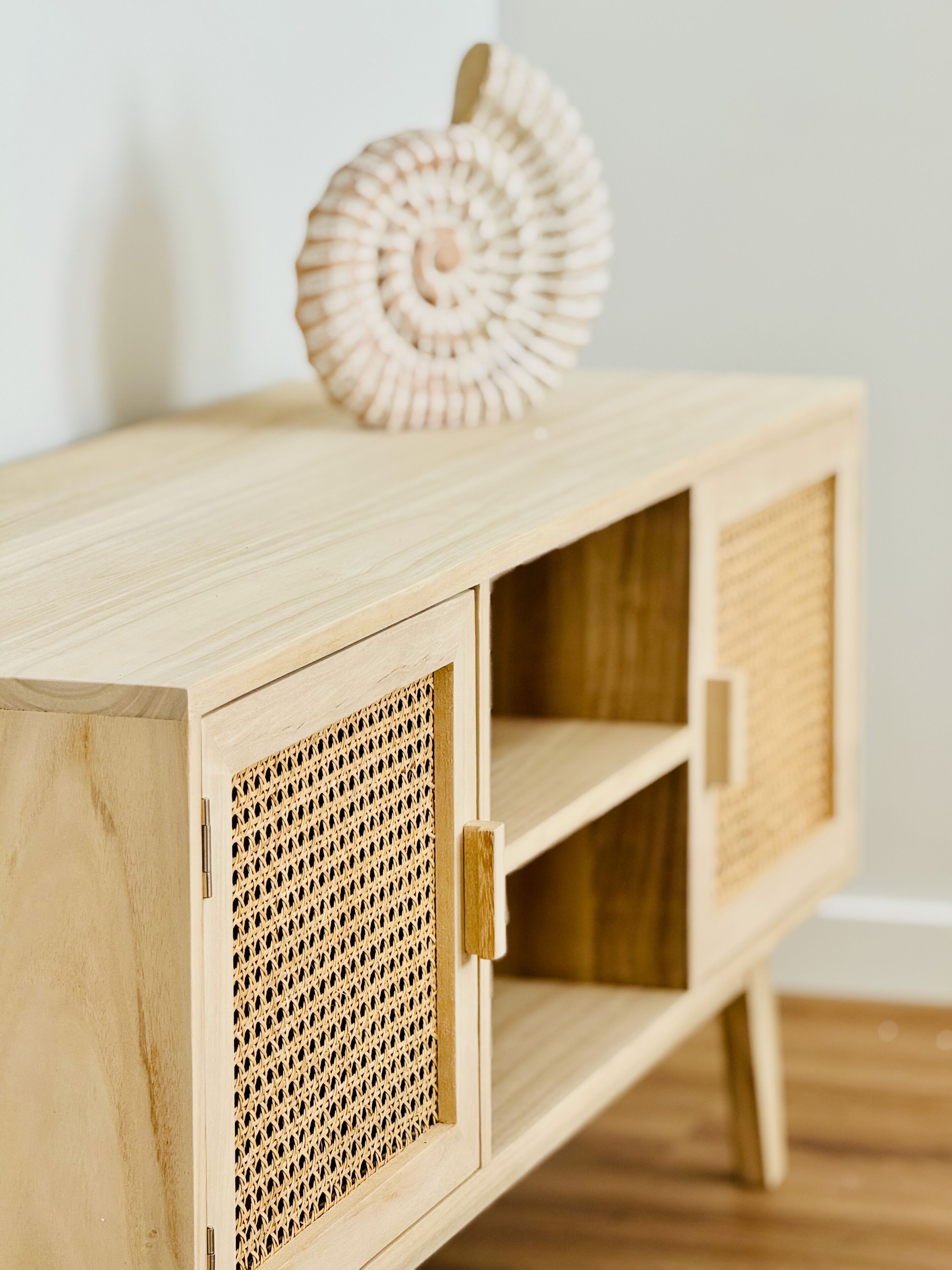 Un mueble de madera con una cesta tejida encima.