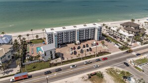 Un hôtel à plusieurs étages doté d’une piscine et offrant une vue sur la plage.