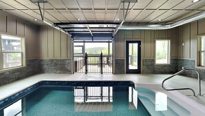 Un espace piscine avec vue sur l’extérieur, un patio couvert et une porte donnant sur l’extérieur.
