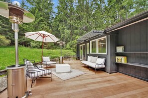 A wooden deck with outdoor furniture, a grill, and a large umbrella. - Escondite | The Hideaway (Delmar Township)
