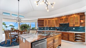 Una cocina moderna con armarios de madera, encimera de granito y lavavajillas integrado.