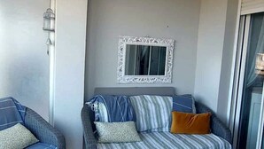 A living room with a sofa, two armchairs, a coffee table, and a decorative chandelier.