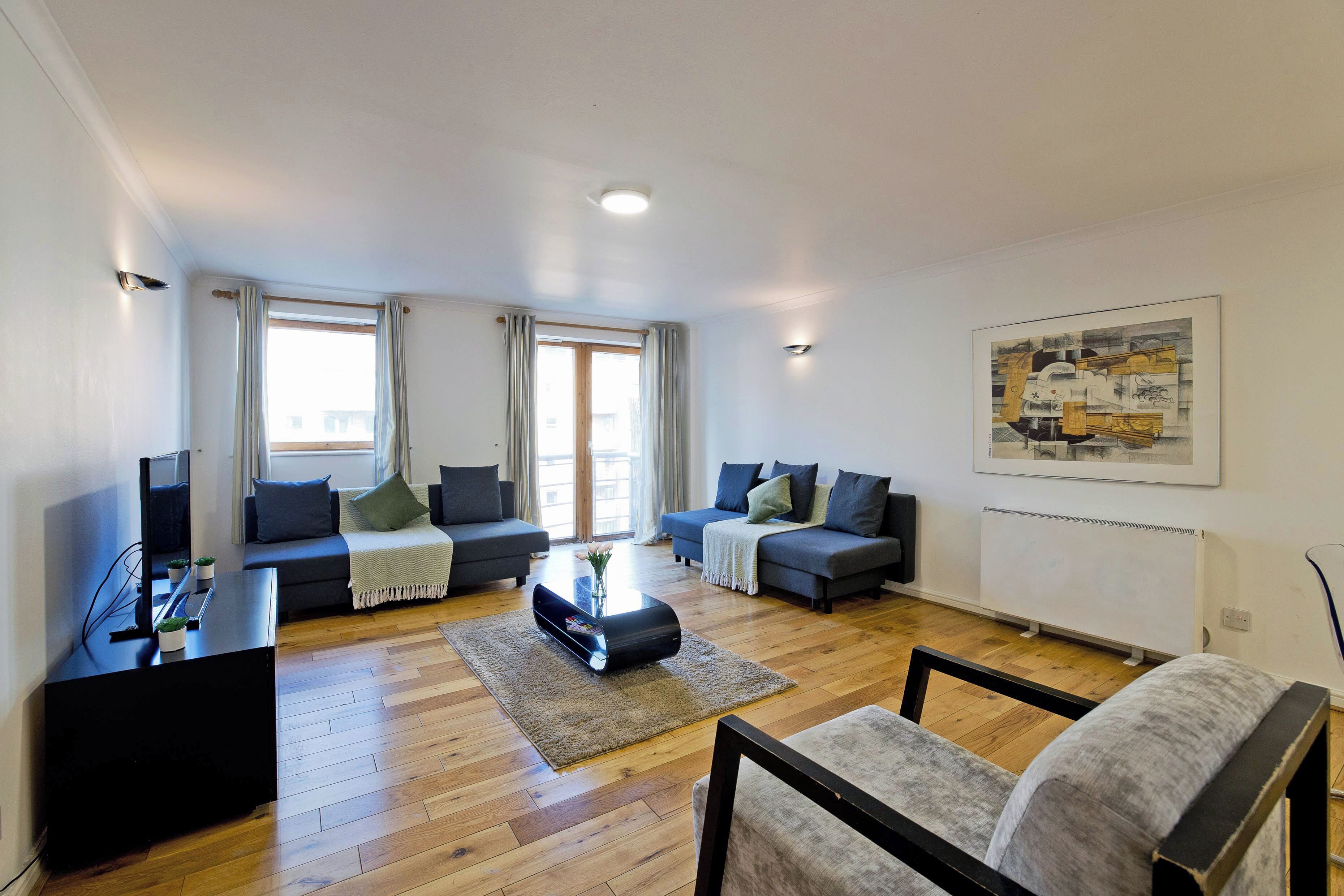 A modern living room with two sofas, a coffee table, and a TV stand.