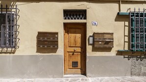 A building with a wooden door, mailboxes, and a number 74 sign. - Porta Romana Charme Flat - Florence Dolce Vita (Florence)