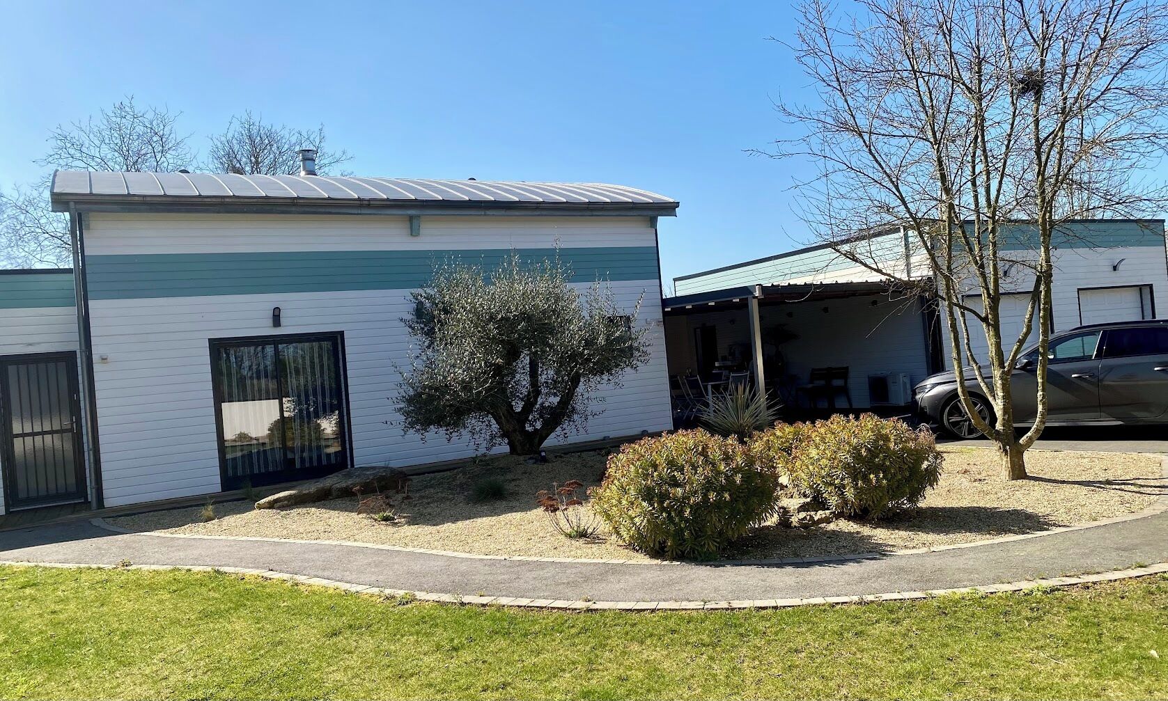 Een laag gebouw met een plat dak, een klein terras en een garage.