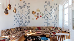 A modern living room with a curved sofa, a wooden coffee table, and a cowhide rug. - Heaven Inn Suites & Terrace (Évora)
