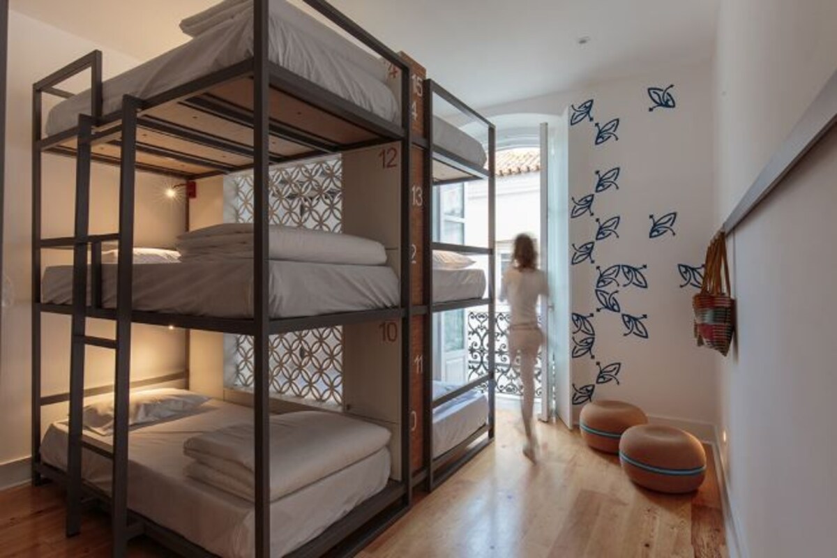 A bunk bed room with a patterned wall and a door leading to another room.