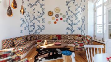 A modern living room with a curved sofa, a wooden coffee table, and a cowhide rug.