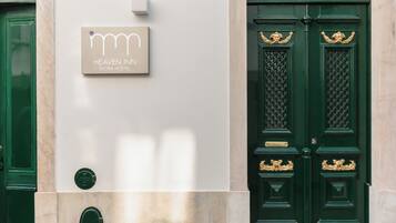 A hotel entrance with a sign reading 'HEAVEN INN ÉVORA HOSTEL.'