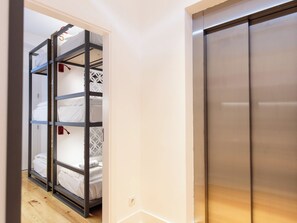 A room with a bunk bed, a wardrobe, and a sliding door. - Heaven Inn Suites & Terrace (Évora)