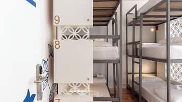 Un dormitorio con literas, puertas numeradas y suelo de madera.