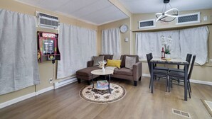Una sala de estar amoblada con sofá, mesa de centro, mesa de comedor y sillas.