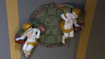 Una placa decorativa con querubines y un rango de fechas de 1800 a 2025.