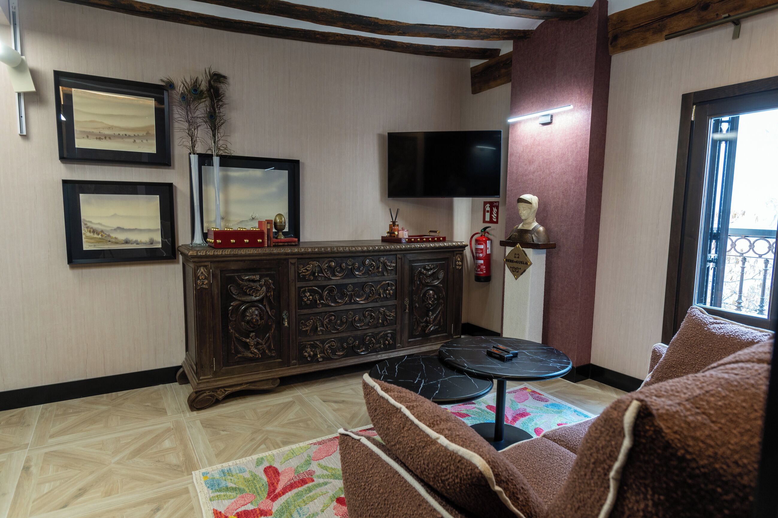 Una sala de estar con un mueble de madera oscura, un televisor de pantalla plana, un extintor y un sofá.