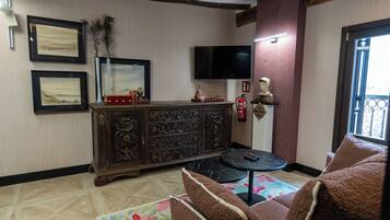Una sala de estar con un mueble de madera oscura, un televisor de pantalla plana, un extintor y un sofá.